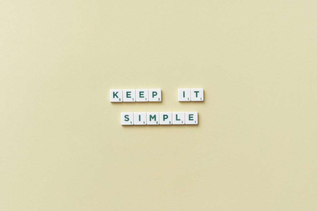 Simple message with Scrabble tiles on a pastel background promoting minimalism.